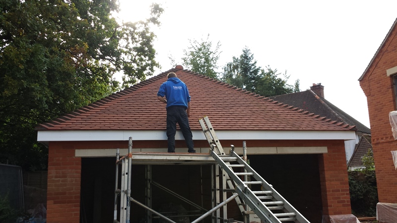 Roofer completing new roof on garage